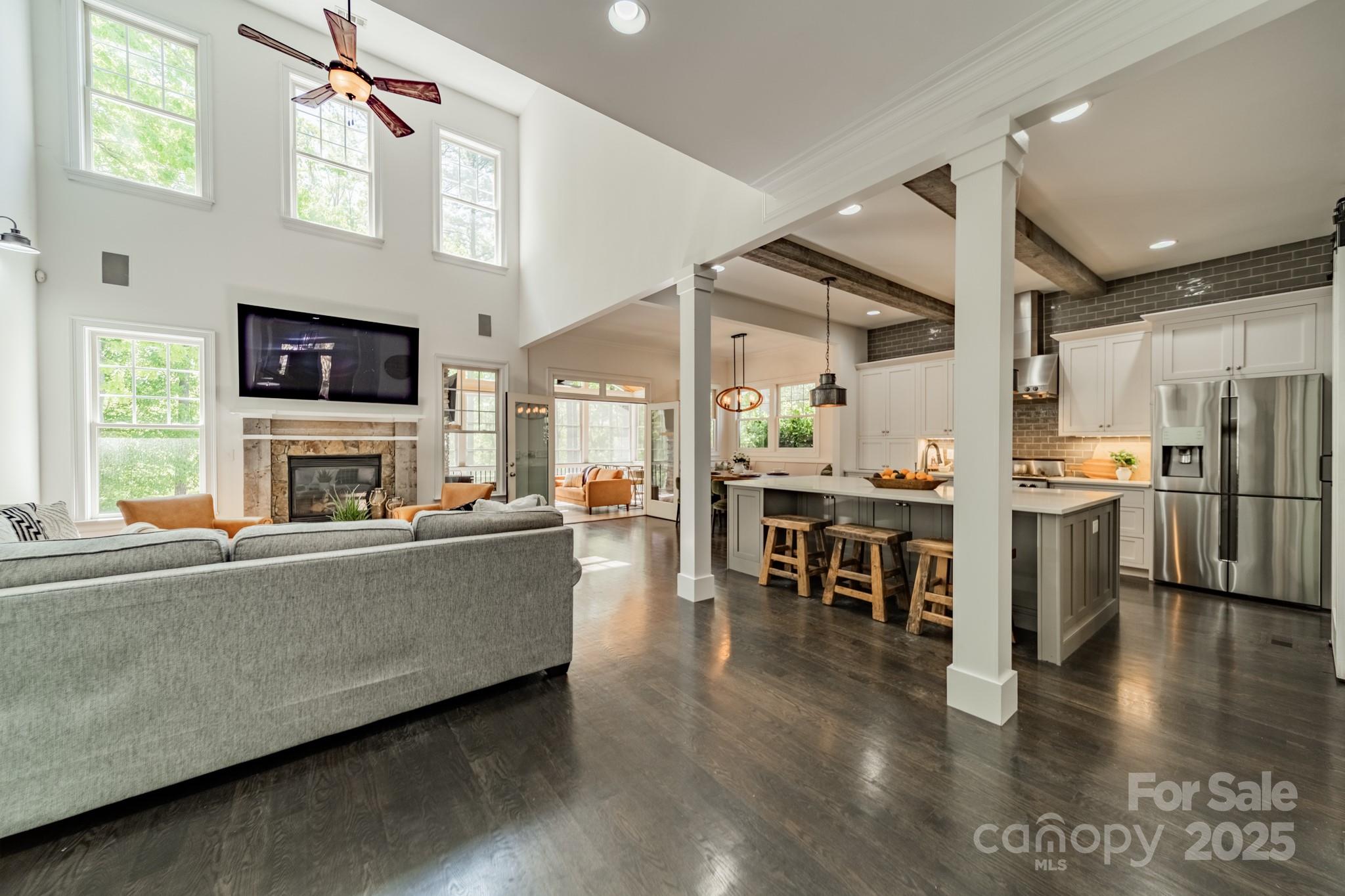 5868 Savona Terrace Fort Mill, SC 29708 - Photo 10 of 46 a living room with stainless steel appliances furniture a fireplace a flat screen tv and a kitchen view