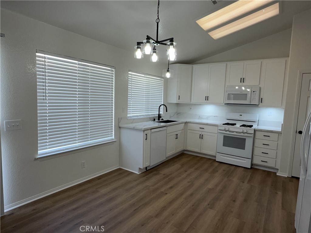 12590 Cobalt Road Victorville, CA 92392 - Photo 16 of 37 a kitchen with stainless steel appliances granite countertop a sink cabinets and a wooden floor