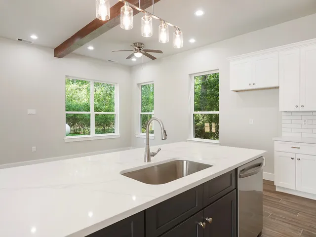 a kitchen with a sink a window and cabinets