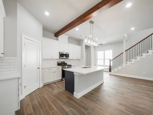 a large white kitchen with kitchen island a stove a sink dishwasher and a refrigerator