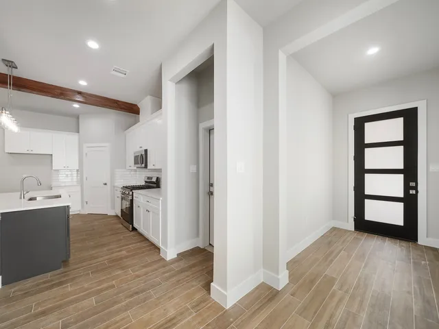 a kitchen with white cabinets and wooden floor