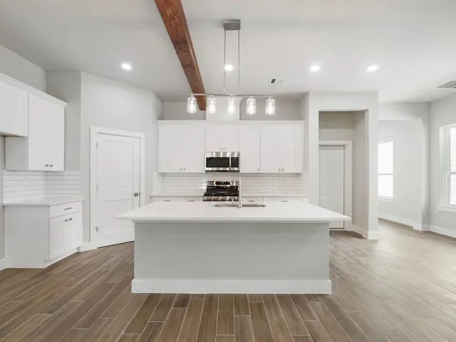 a kitchen with kitchen island a sink and wooden floor