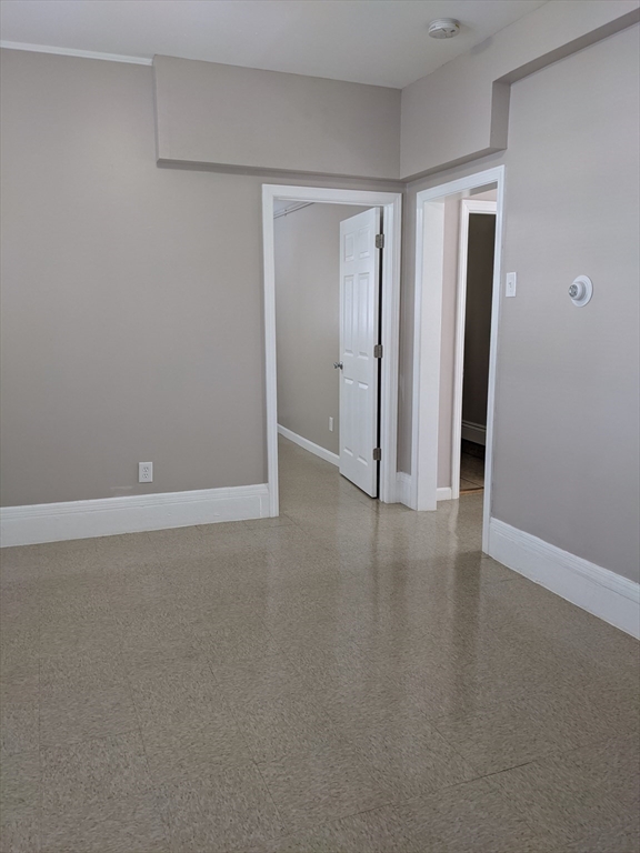 66 Batchelder Street, Unit 2 Boston, MA 02119 - Photo 6 of 8 a view of an empty room with wooden floor and closet