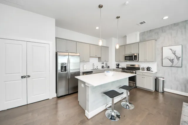 a large kitchen with kitchen island a sink a stove a dining table and chairs