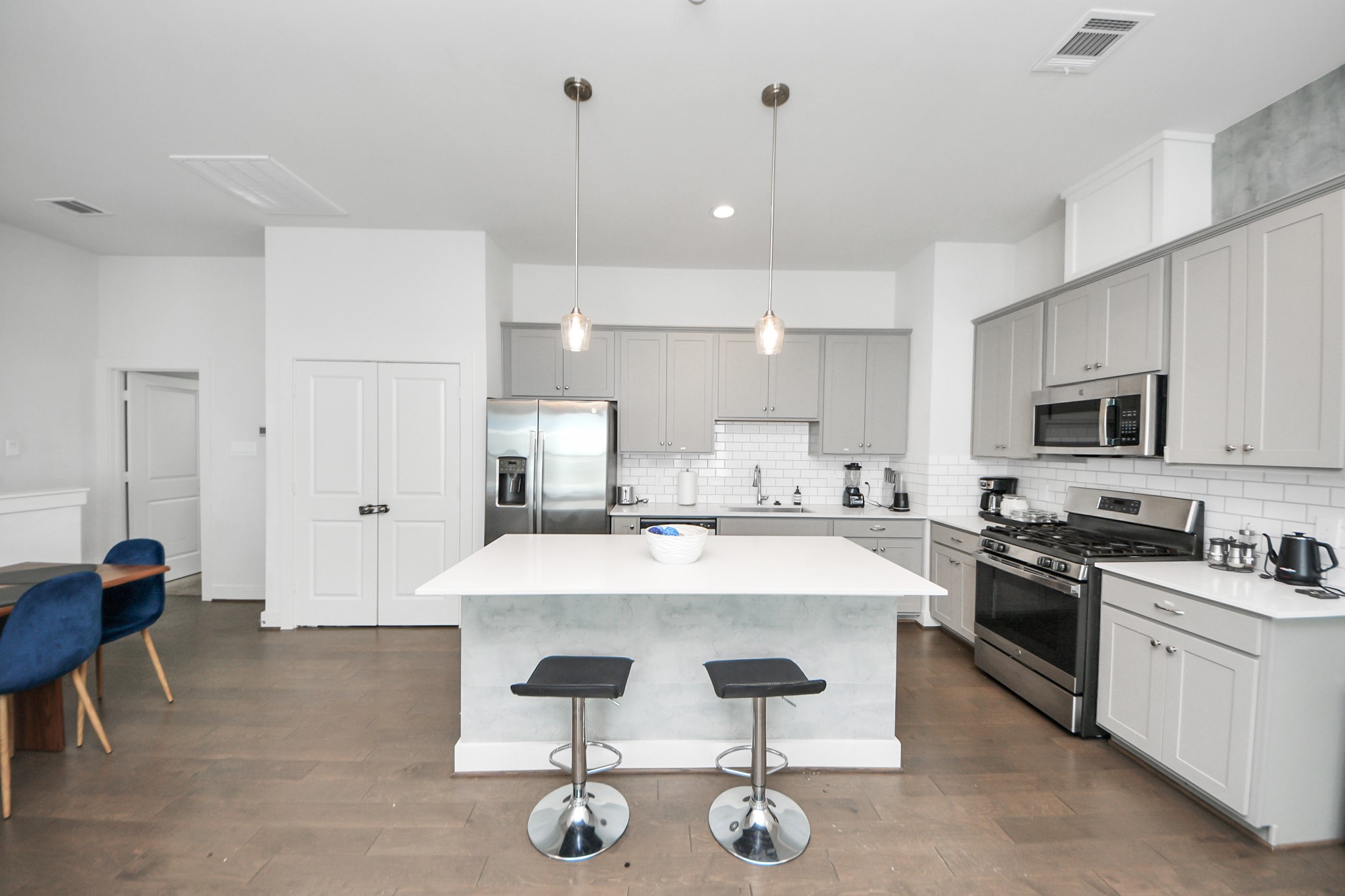 3642 Griggs Road Houston, TX 77021 - Photo 25 of 39 a kitchen with stainless steel appliances kitchen island granite countertop a stove a sink a dining table and chairs with wooden floor