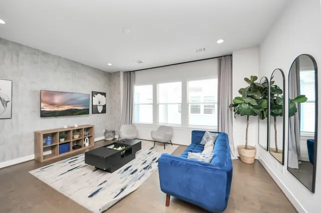 a bedroom with a bed and a large window with wooden floor