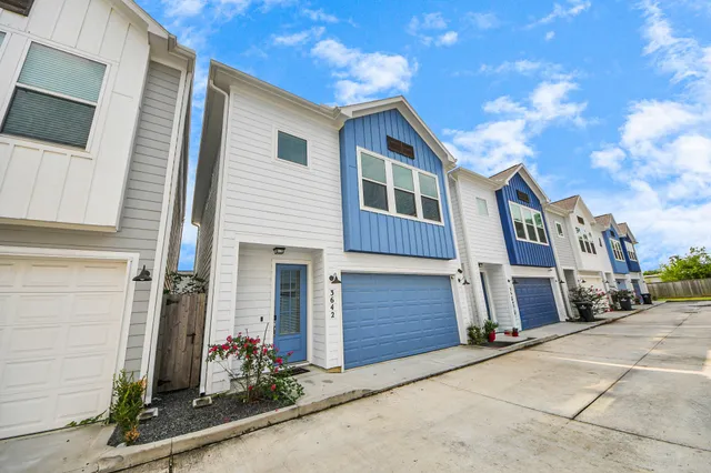 an aerial view of residential houses with outdoor space and ocean view