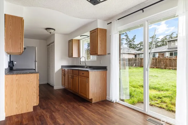 a kitchen with wooden floors and wide window