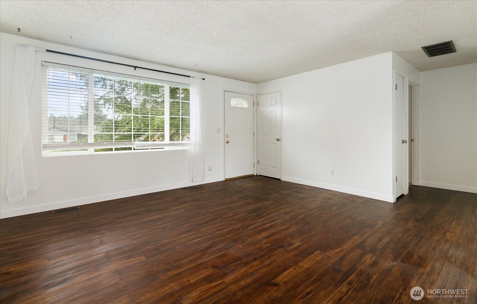 1146 Ridgeway Drive Oak Harbor, WA 98277 - Photo 5 of 25 a view of an empty room with wooden floor and a window