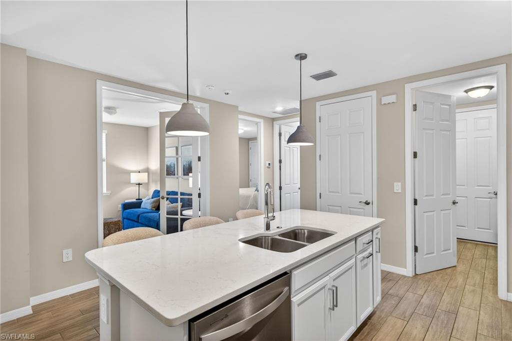 14567 Edgewater Circle Naples, FL 34114 - Photo 11 of 44 a kitchen with a sink a counter space and wooden floor