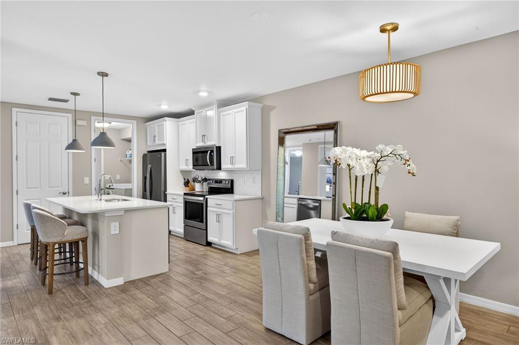 14567 Edgewater Circle Naples, FL 34114 - Photo 13 of 44 a kitchen with kitchen island stainless steel appliances a dining table chairs and sink