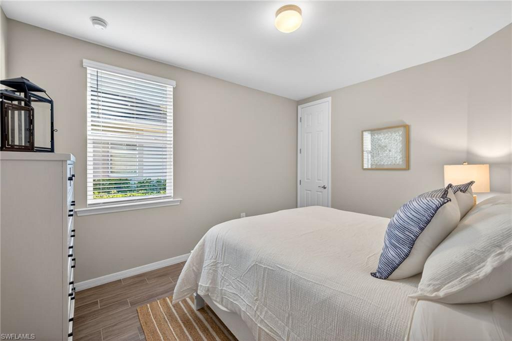 14567 Edgewater Circle Naples, FL 34114 - Photo 23 of 44 a bedroom with a bed and wooden floor