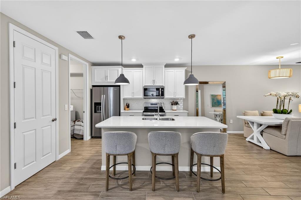 14567 Edgewater Circle Naples, FL 34114 - Photo 8 of 44 a large kitchen with a table and chairs