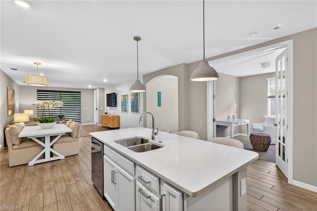 14567 Edgewater Circle Naples, FL 34114 - Photo 10 of 44 a kitchen that has a table chairs in it and wooden floors