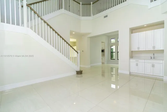 a view of kitchen with stainless steel appliances granite countertop a stove a sink a microwave and a refrigerator