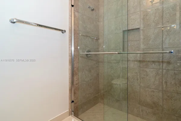 a bathroom with a granite countertop sink a mirror and shower
