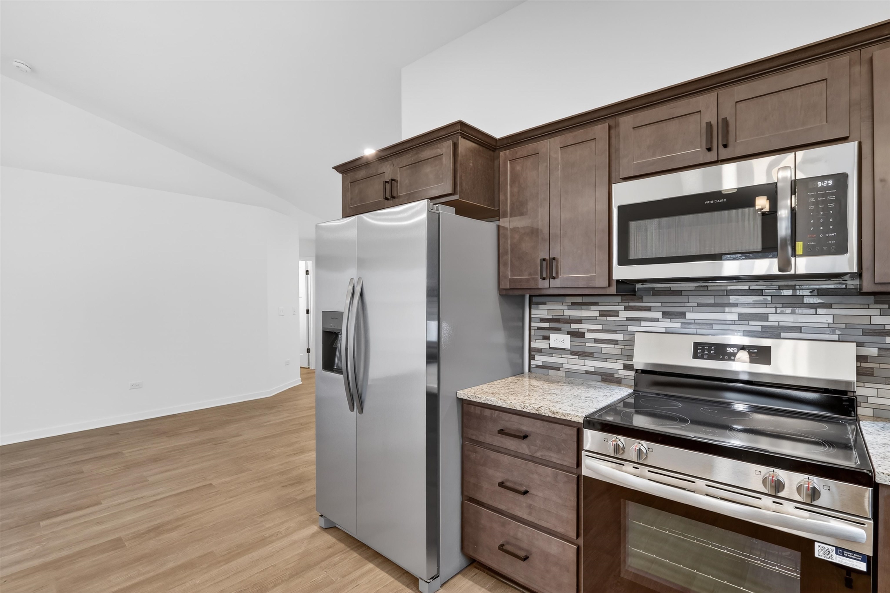 307 West South Street Durand, IL 61024 - Photo 15 of 27 a kitchen with granite countertop cabinets stainless steel appliances and wooden floor