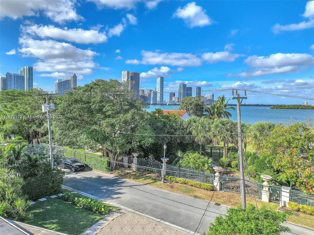 a view of a city with flower plants and wooden fence
