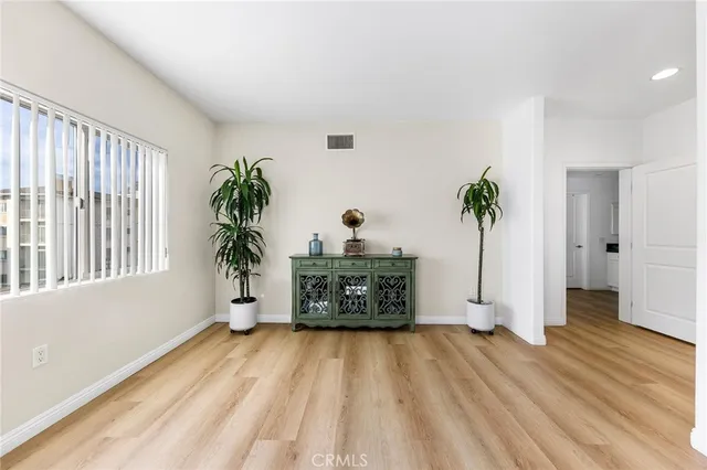 a living room with a potted plant and a wooden floor
