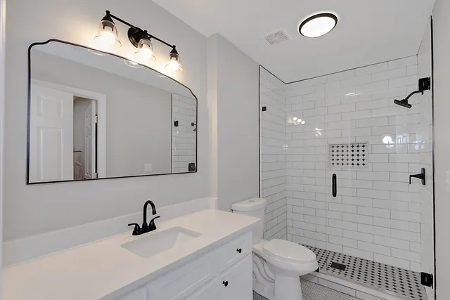 a bathroom with a sink a toilet and shower