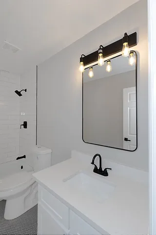 a bathroom with a sink a toilet and a mirror
