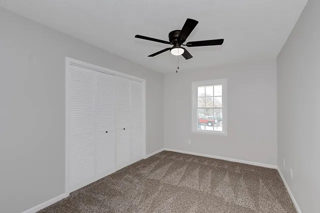 a view of a livingroom with a ceiling fan & window