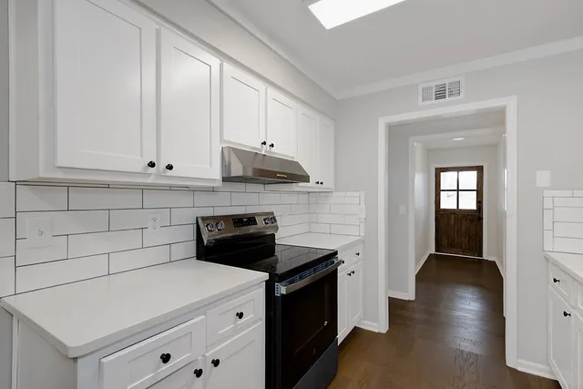 a kitchen with stainless steel appliances a stove microwave and cabinets