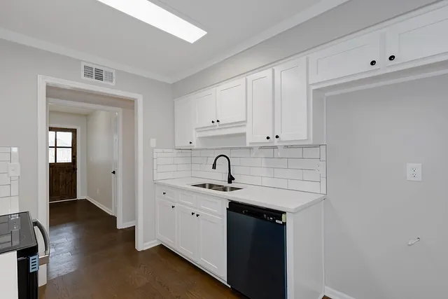 a kitchen with granite countertop white cabinets and sink