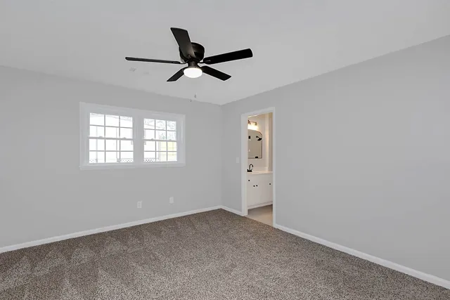a view of a livingroom with a ceiling fan and window