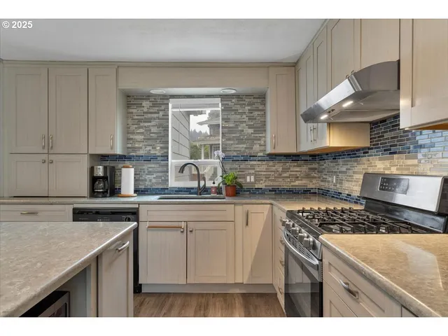 a kitchen with stainless steel appliances granite countertop a sink stove and cabinets