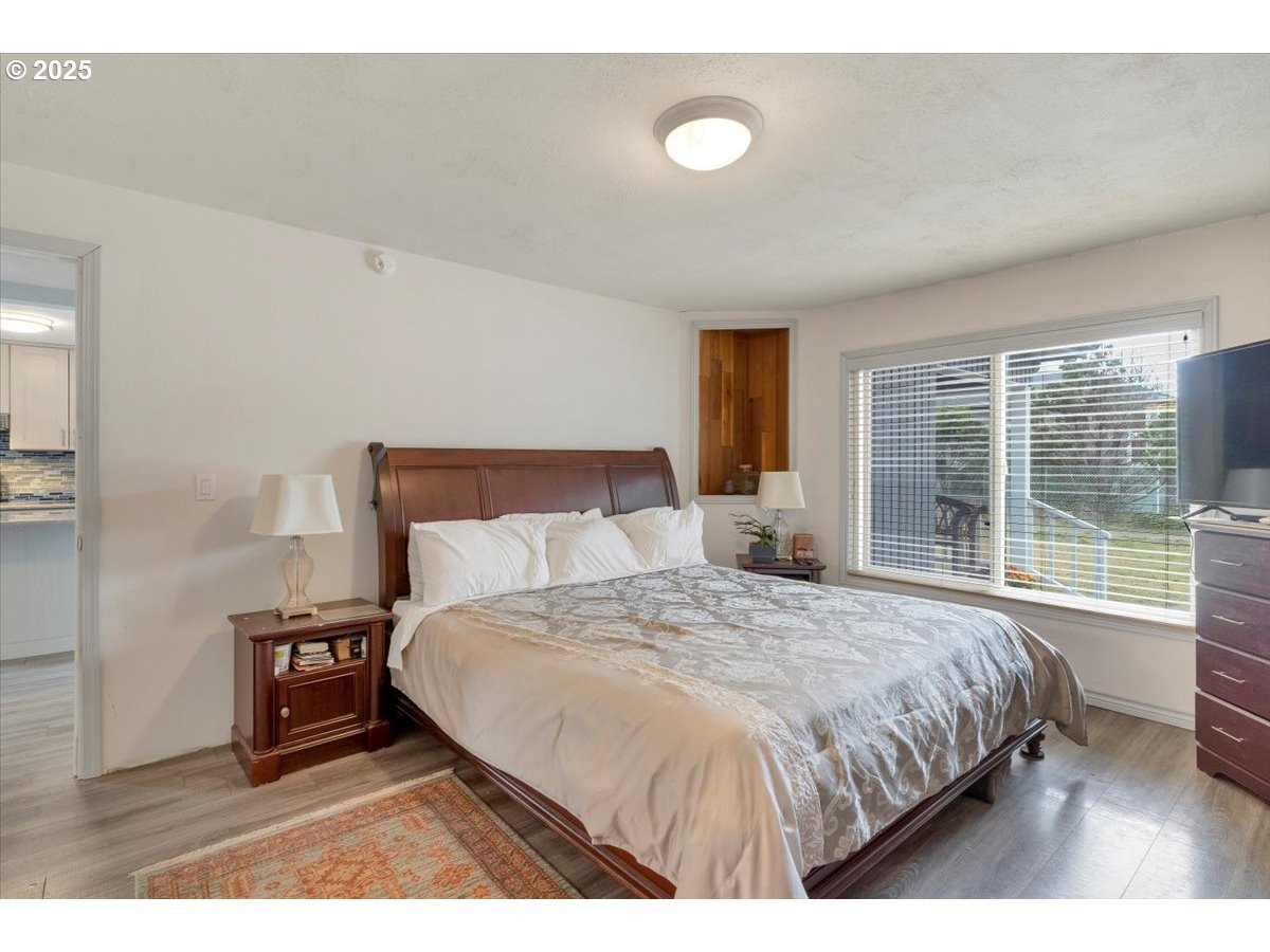 60 Raven Lane Depoe Bay, OR 97341 - Photo 23 of 43 a bedroom with a bed a large window with outer view and couch