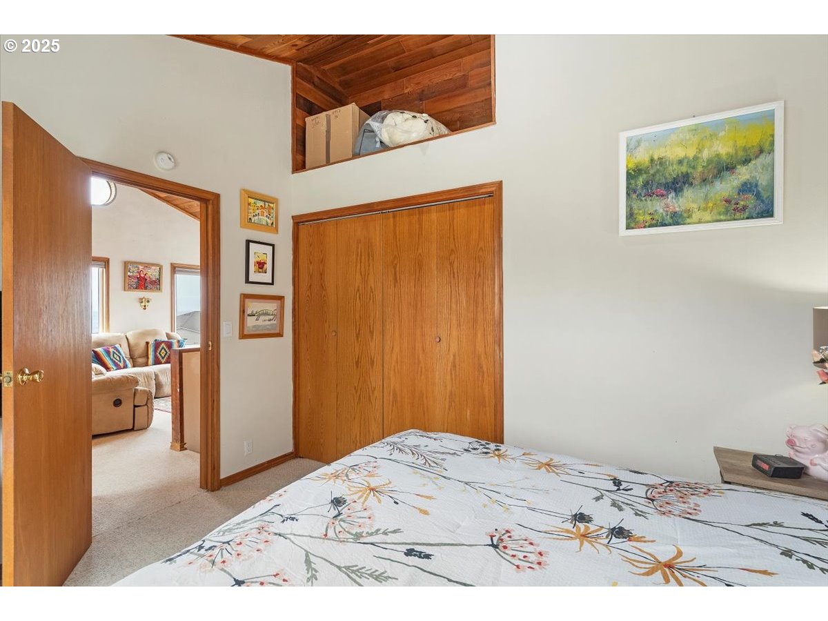60 Raven Lane Depoe Bay, OR 97341 - Photo 33 of 43 a bedroom with a bed and a painting on the wall