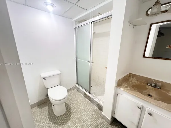 a bathroom with a granite countertop sink toilet and shower