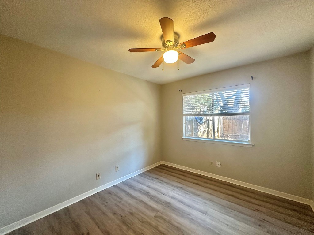 11907 Argonne Forest Trail, Unit B Austin, TX 78759 - Photo 8 of 11 Unfurnished room with wood finished floors, a textured ceiling, and a ceiling fan