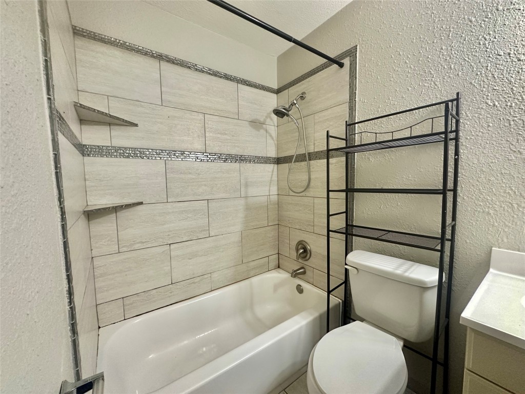 11907 Argonne Forest Trail, Unit B Austin, TX 78759 - Photo 9 of 11 Full bathroom featuring a textured wall, vanity, and shower / bathtub combination