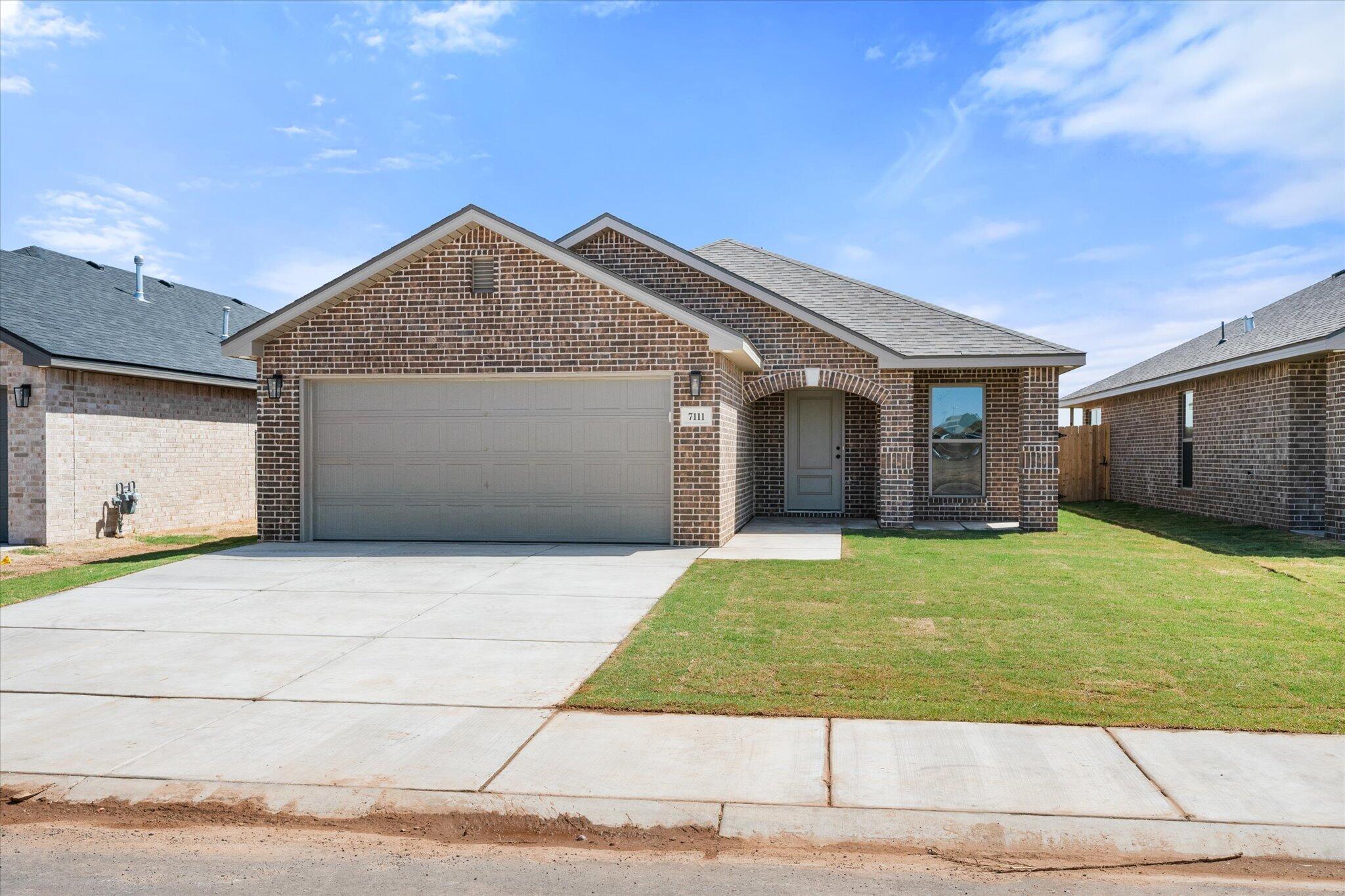 7111 14th Street Lubbock, TX 79416 - Photo 1 of 25 a front view of a house with a yard and garage