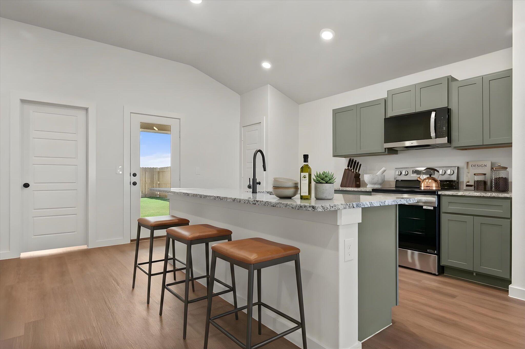 7111 14th Street Lubbock, TX 79416 - Photo 11 of 25 a kitchen with stainless steel appliances granite countertop a stove top oven a sink a refrigerator white cabinets and wooden floor