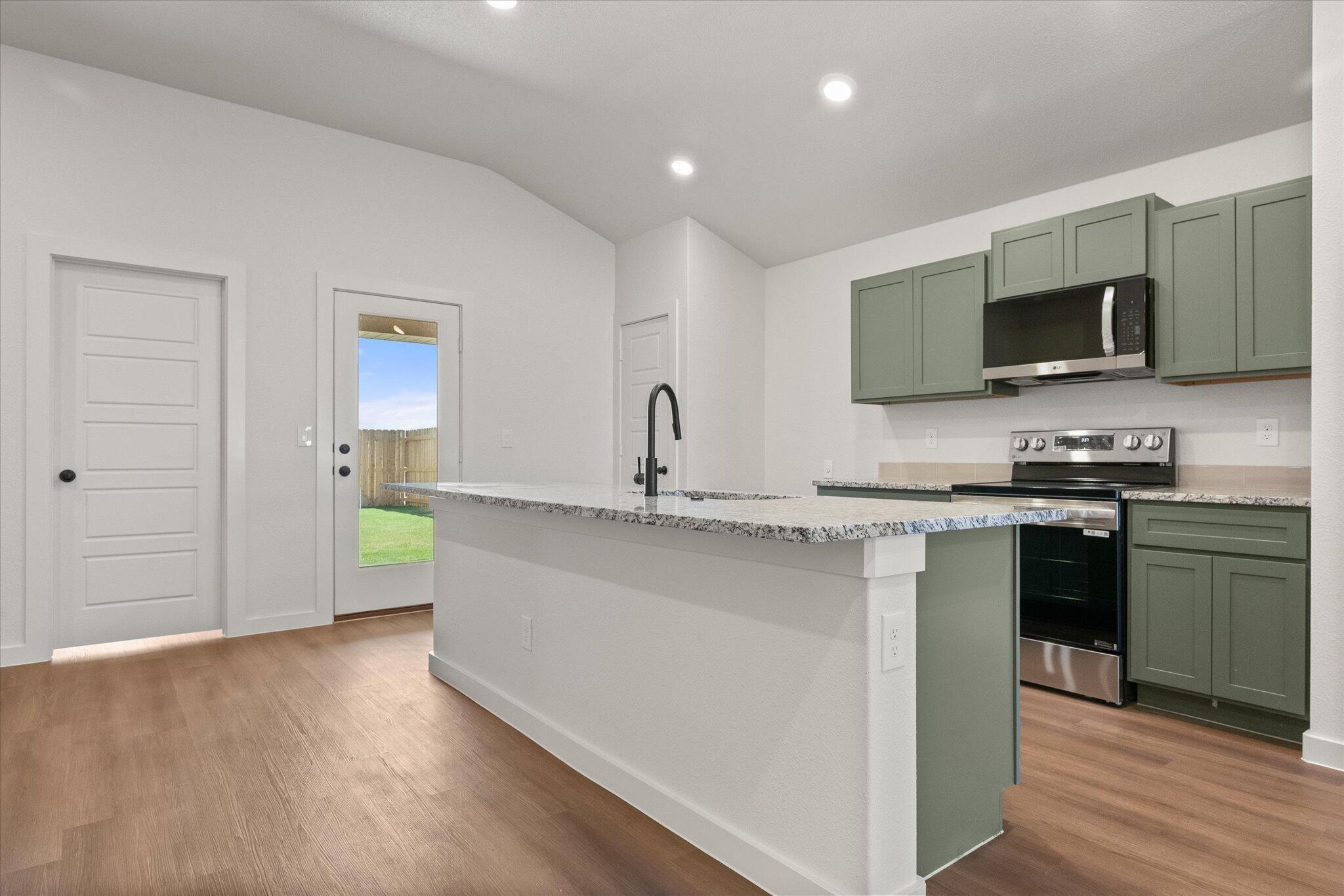 7111 14th Street Lubbock, TX 79416 - Photo 12 of 25 a kitchen with stainless steel appliances a sink stove and microwave
