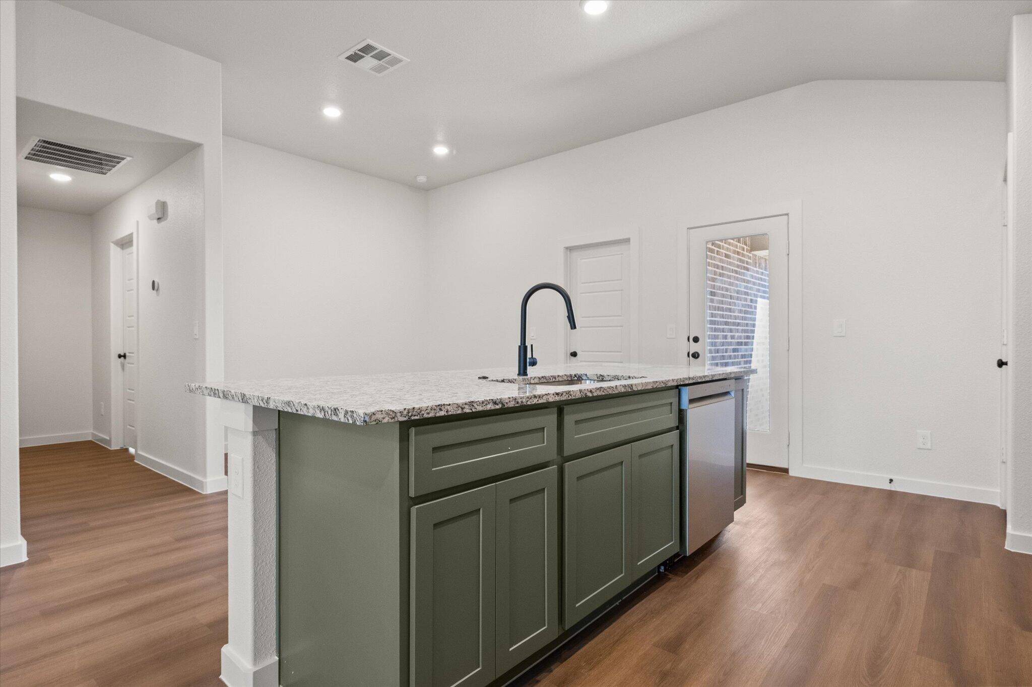 7111 14th Street Lubbock, TX 79416 - Photo 13 of 25 a kitchen with a sink cabinets and wooden floor