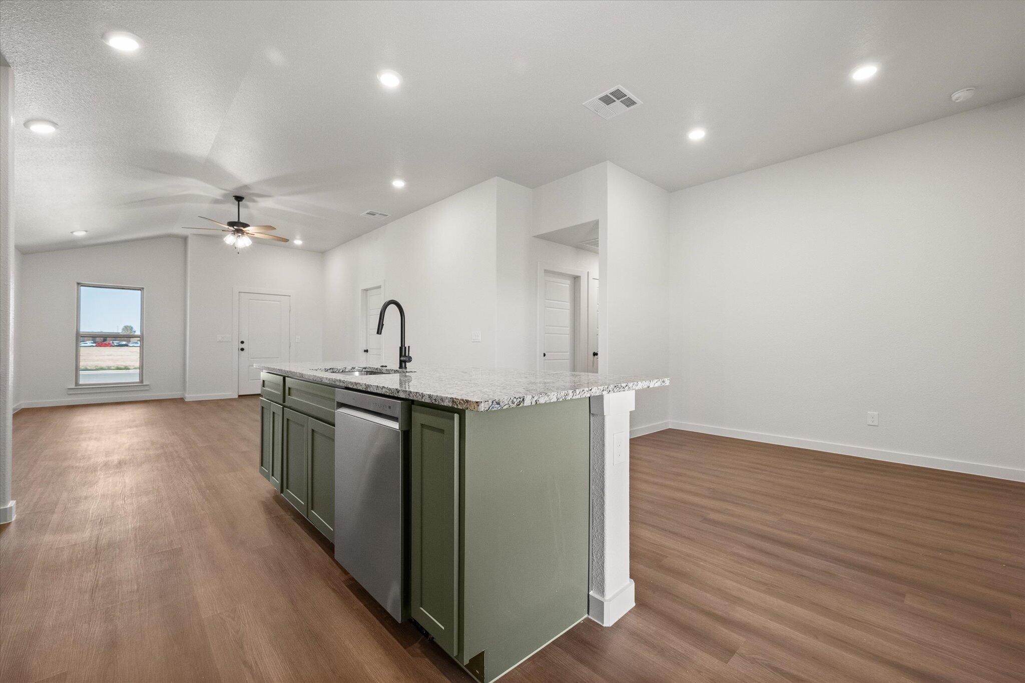 7111 14th Street Lubbock, TX 79416 - Photo 14 of 25 a kitchen with stainless steel appliances granite countertop a sink a stove and a wooden floors
