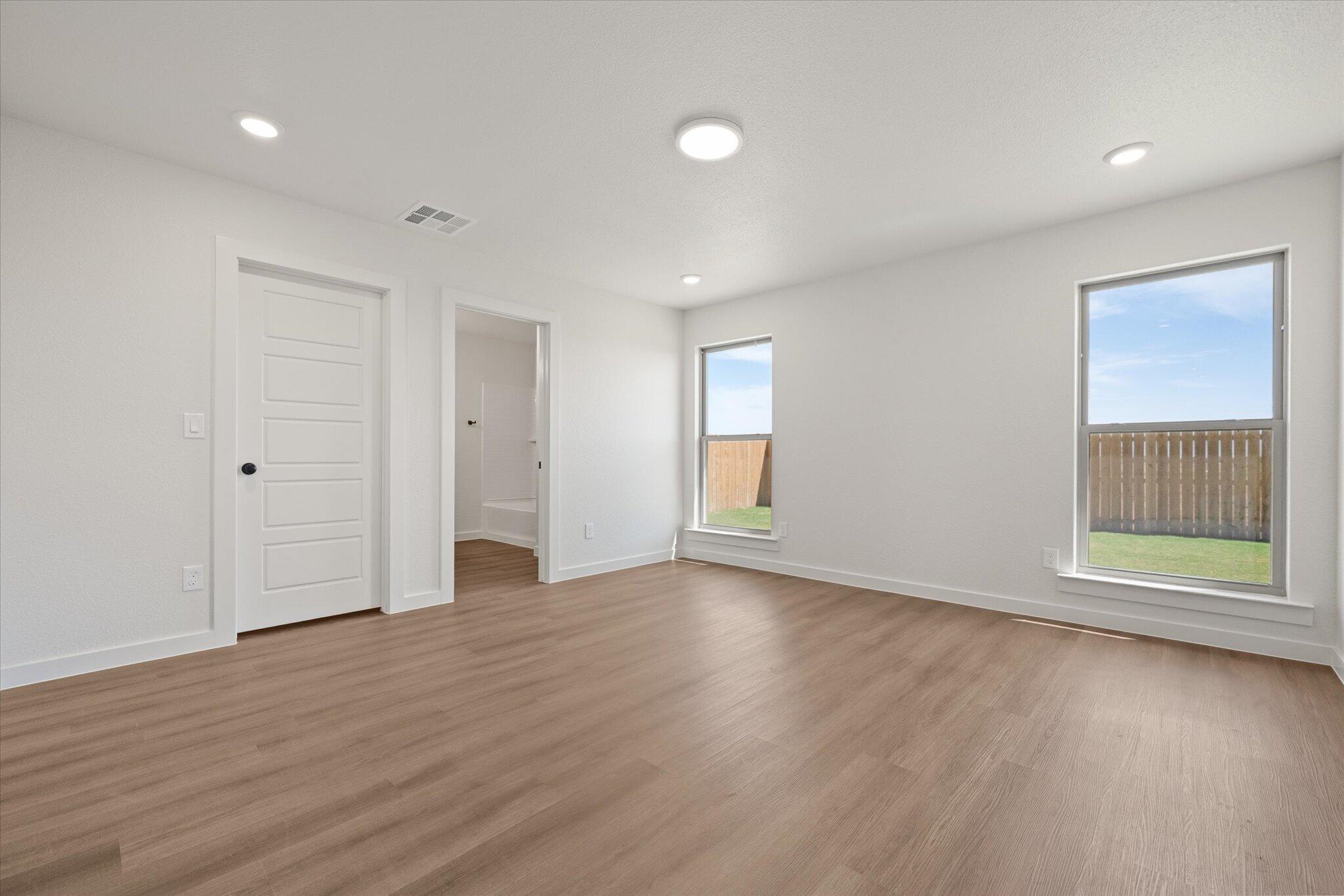 7111 14th Street Lubbock, TX 79416 - Photo 17 of 25 an empty room with wooden floor and windows