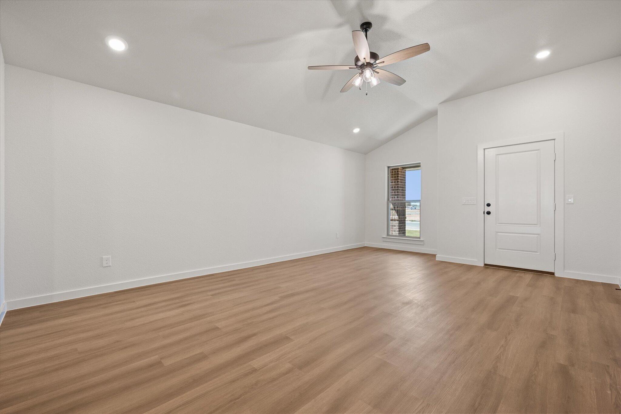 7111 14th Street Lubbock, TX 79416 - Photo 8 of 25 an empty room with wooden floor fan and windows