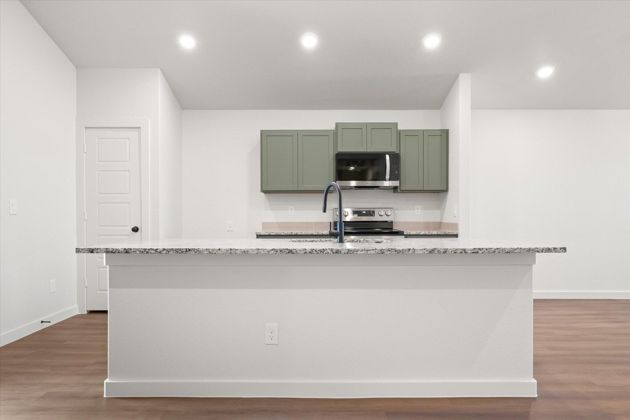 7111 14th Street Lubbock, TX 79416 - Photo 9 of 25 a kitchen with a sink cabinets and wooden floor