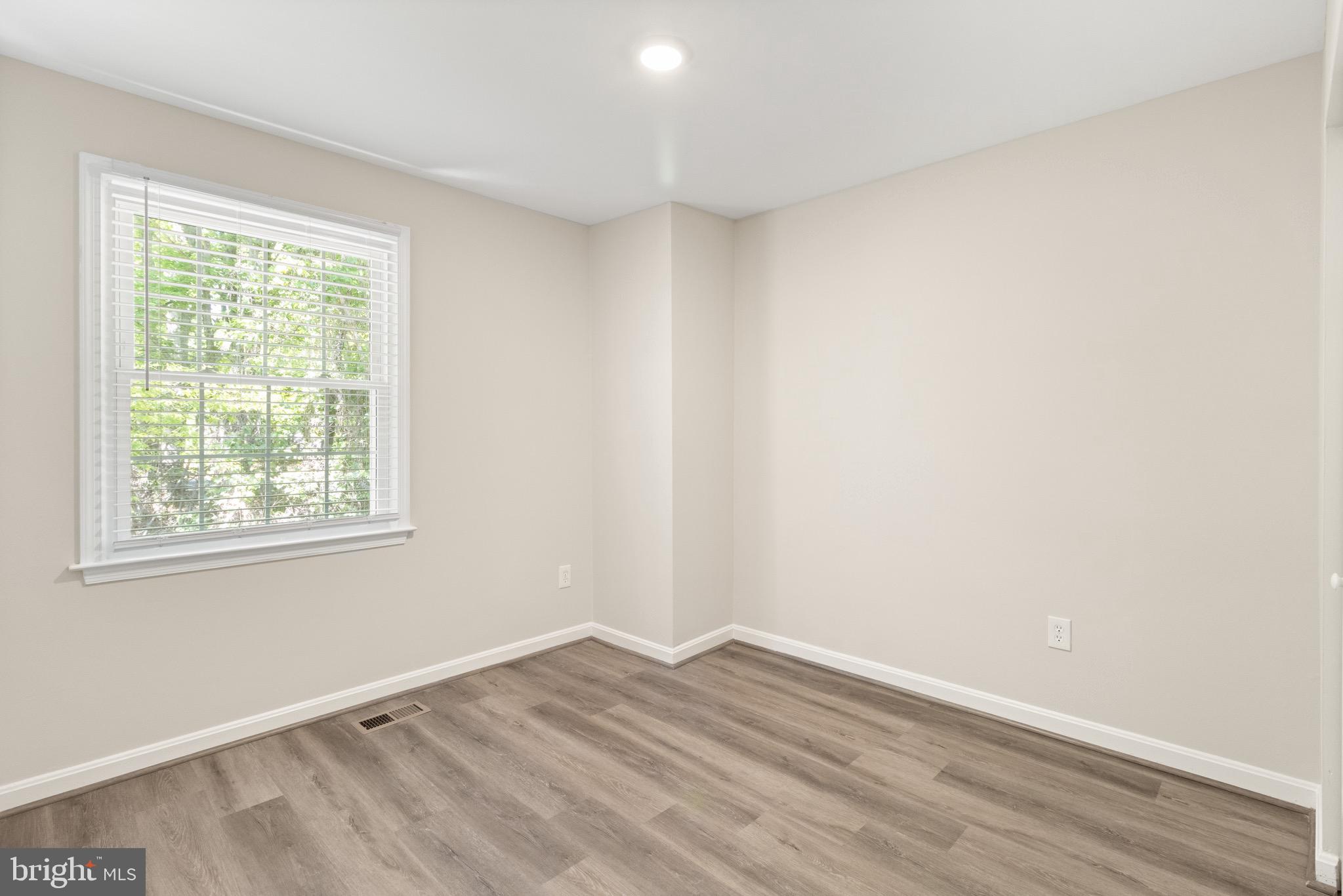 8581 Chester Grove Court Springfield, VA 22153 - Photo 26 of 38 an empty room with wooden floor and windows