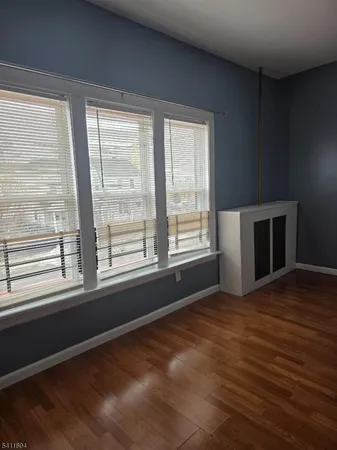 a view of empty room with wooden floor and fireplace