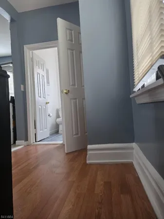 a view of empty room with wooden floor and window