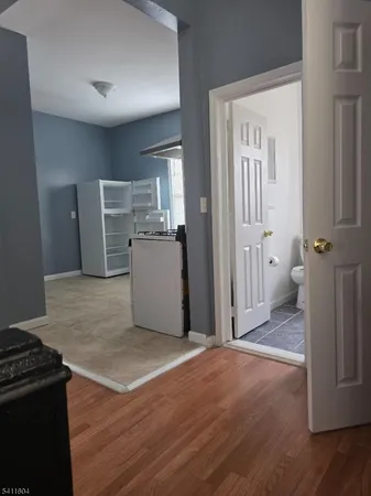 a view of a kitchen with refrigerator and wooden floor