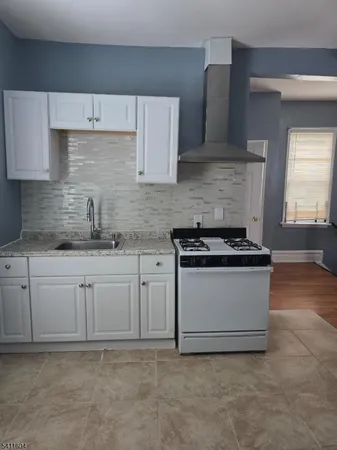 a kitchen with granite countertop white cabinets and white appliances