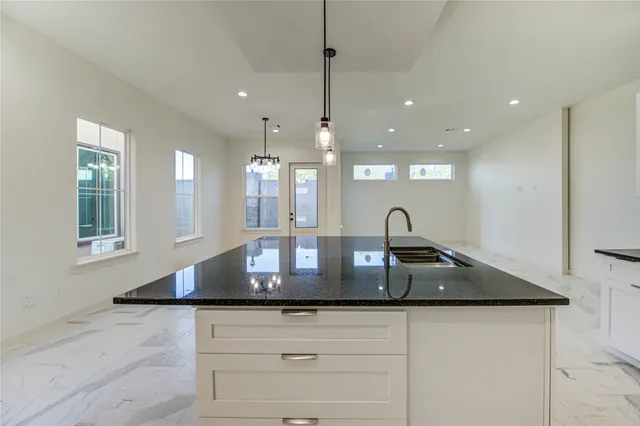 a kitchen with kitchen island a sink stainless steel appliances and a counter top space