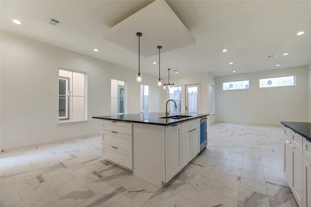 a large kitchen with granite countertop a sink and a white stove